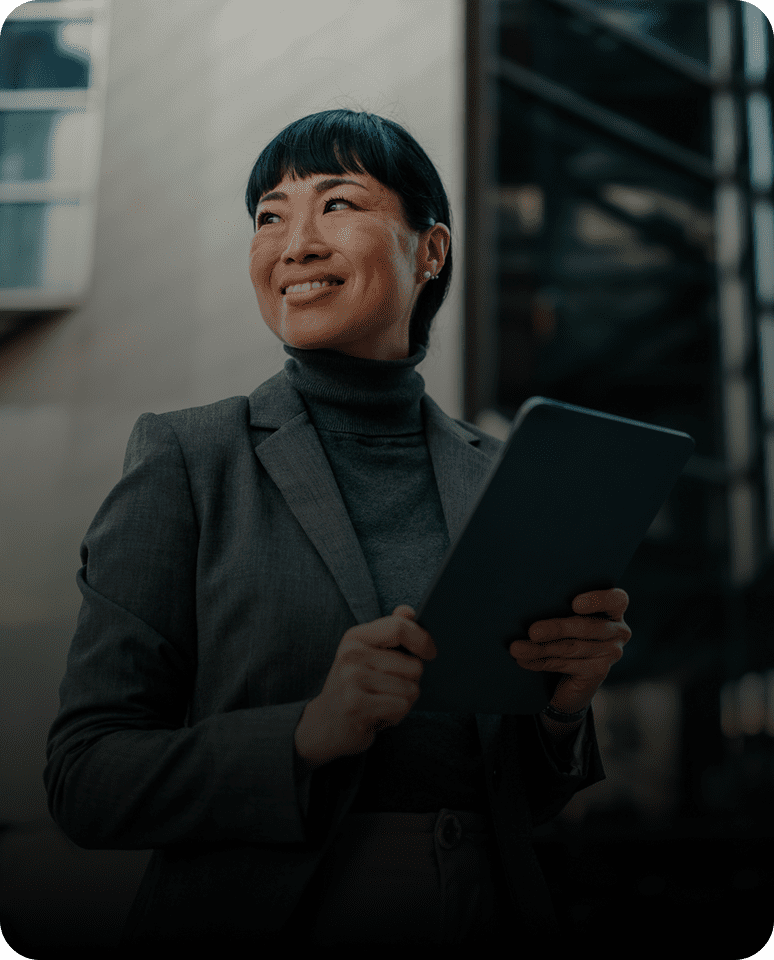 Confident professional woman holding a tablet, smiling.