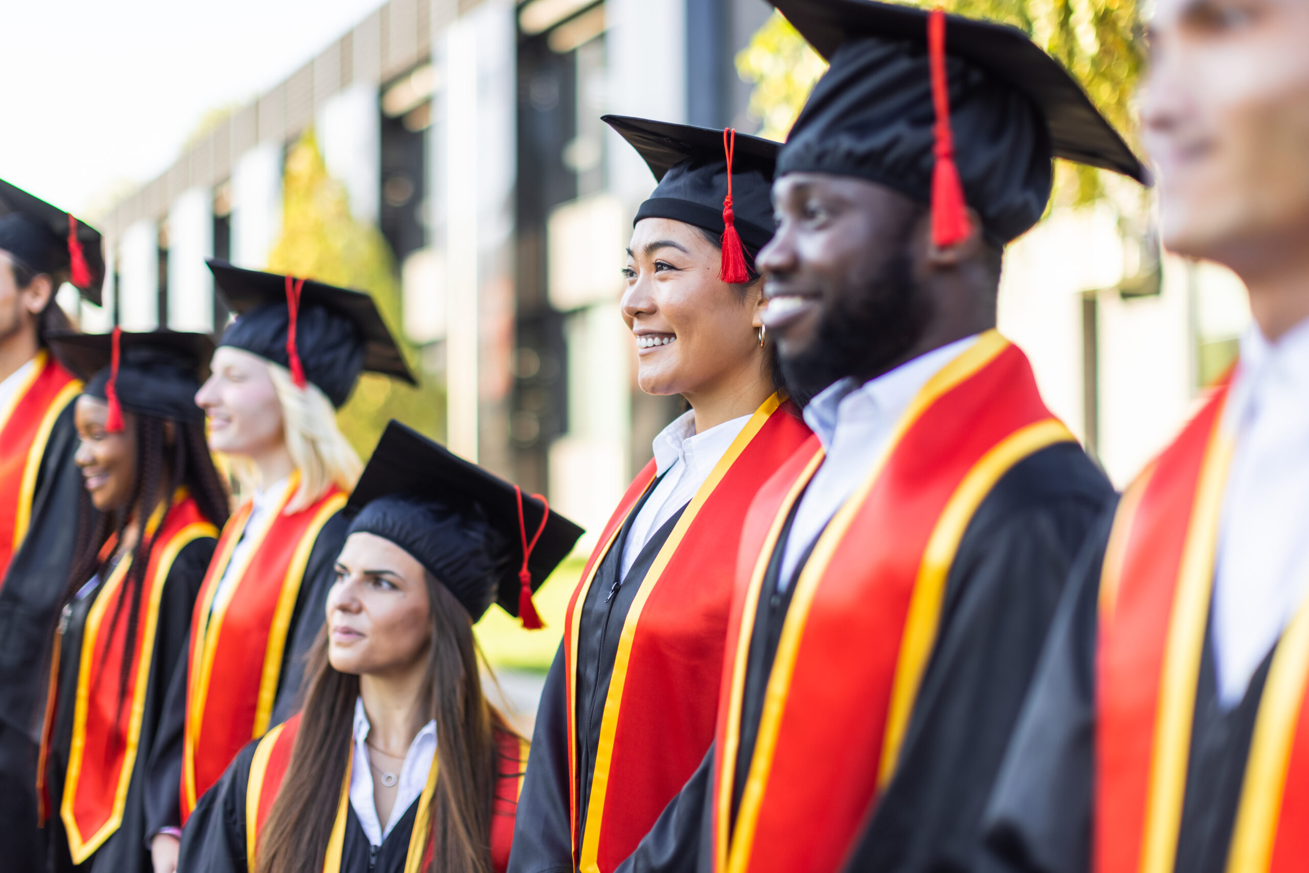 Graduates in caps and gowns celebrating at a ceremony.