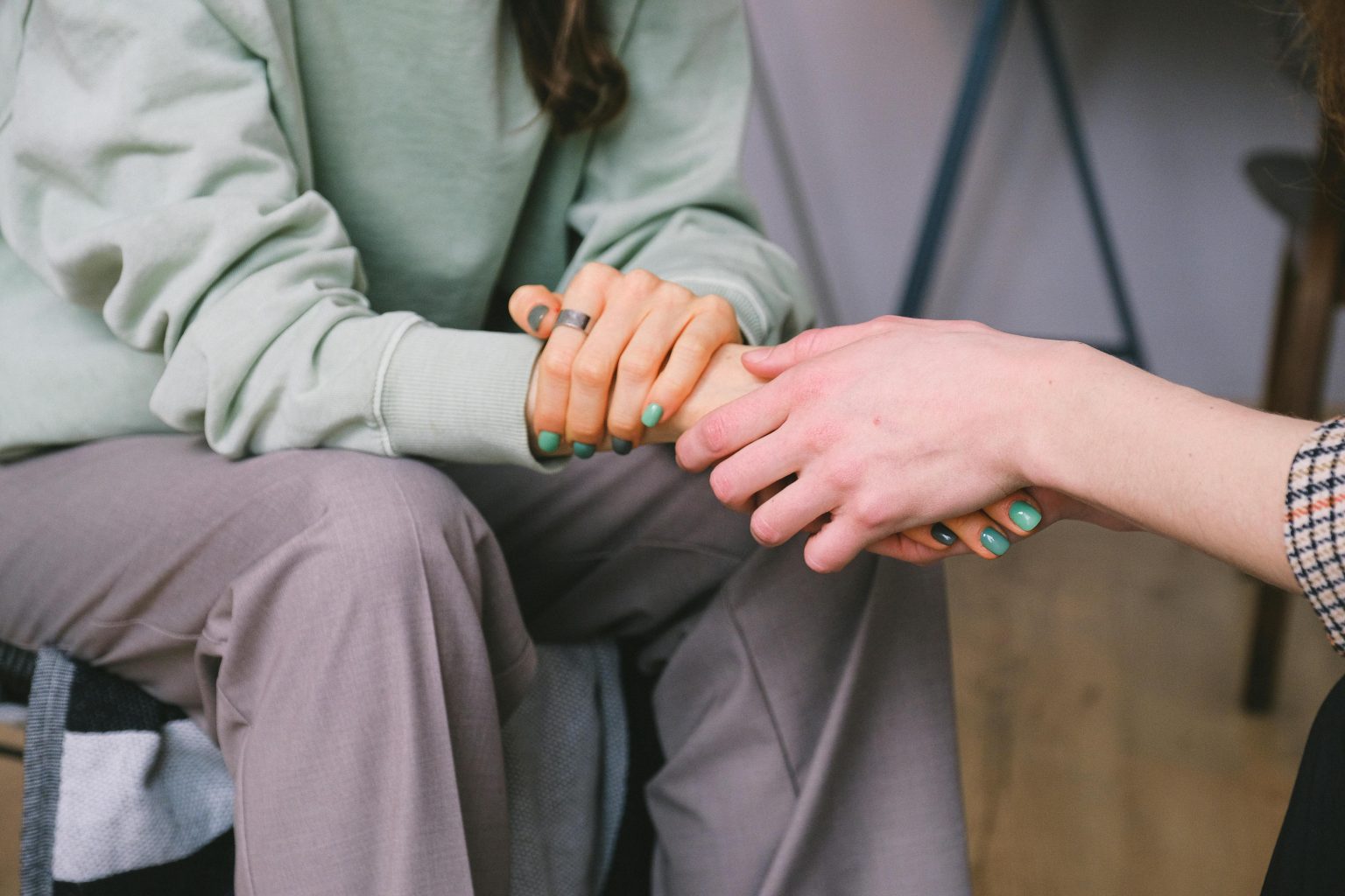 Two people holding hands in a comforting gesture.