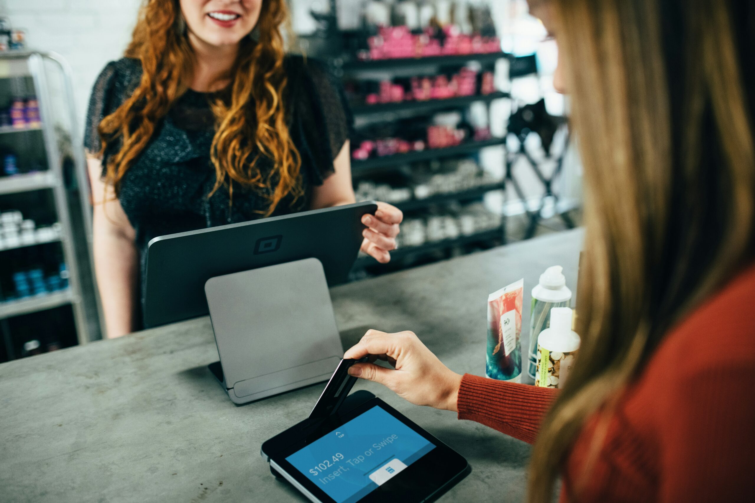 A customer making a payment at a store counter with a tablet.